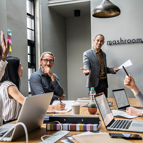 Depicting a coaching and mentoring session with someone standing in front of the group engaged in conversation