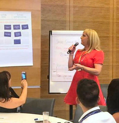 Pips Bunce presenting at a whiteboard to a group to depict the guiding, partnership and thought leadership services offered.